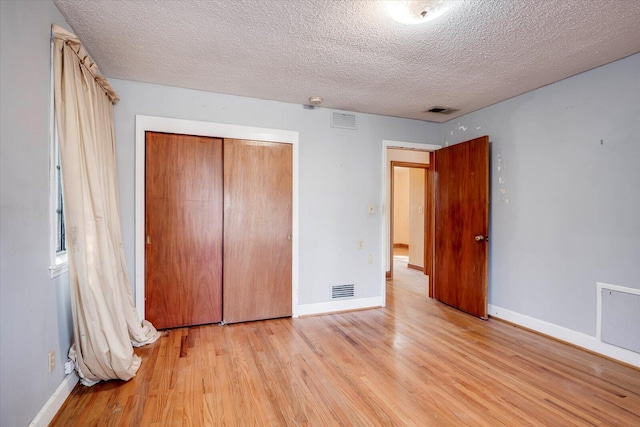 unfurnished bedroom with visible vents and light wood finished floors