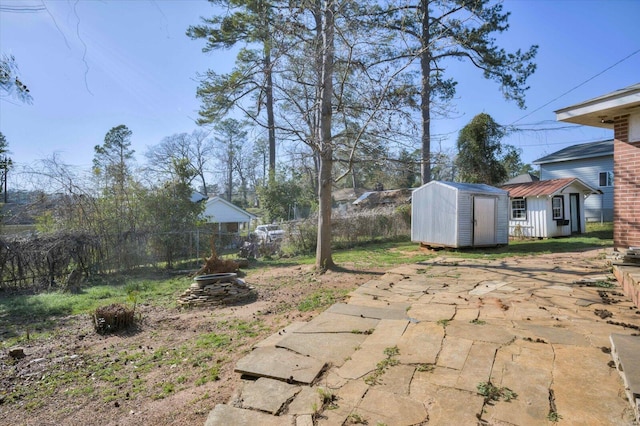 view of yard with fence, an outdoor structure, and a shed