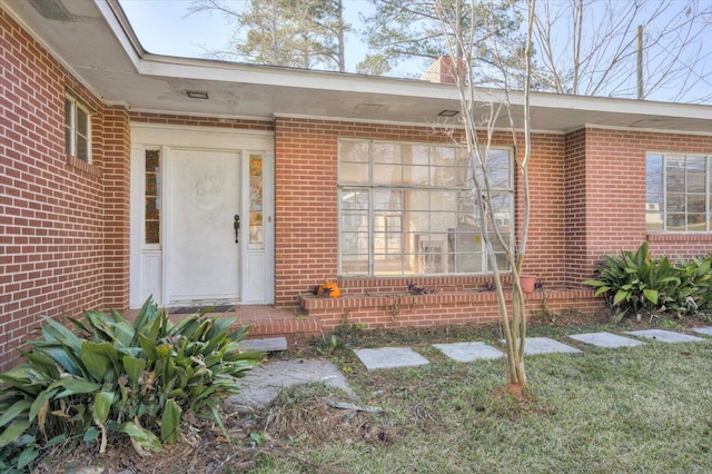 property entrance featuring brick siding