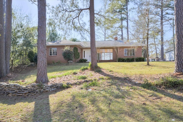 ranch-style house featuring a front lawn, a garage, brick siding, and a chimney