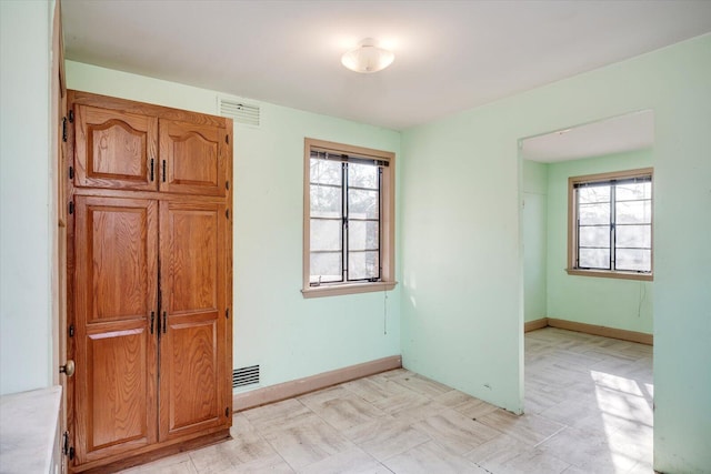 spare room with visible vents, baseboards, and a healthy amount of sunlight