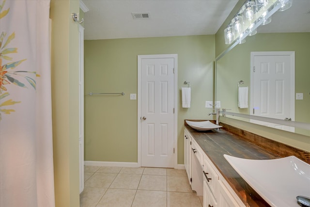 full bathroom with double vanity, visible vents, tile patterned flooring, and a sink