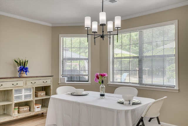 dining area featuring a wealth of natural light, crown molding, and a chandelier