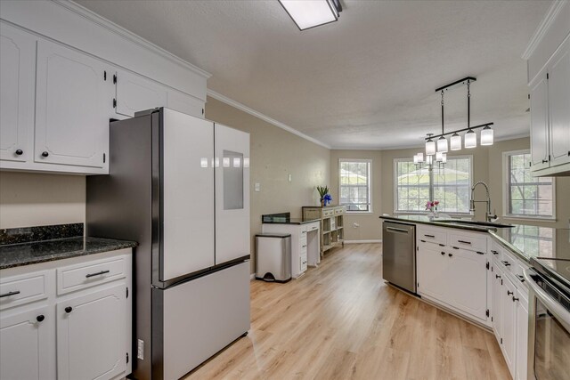 kitchen featuring appliances with stainless steel finishes, a sink, white cabinetry, and light wood-style flooring