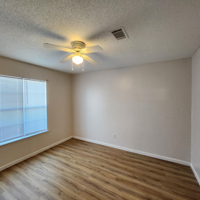 unfurnished room with a textured ceiling, light hardwood / wood-style flooring, and ceiling fan