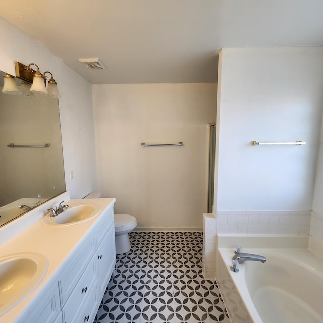 bathroom featuring vanity, toilet, and a tub to relax in