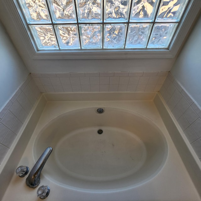 bathroom featuring a tub to relax in and a wealth of natural light