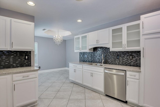 kitchen with white cabinets, sink, stainless steel dishwasher, light stone countertops, and light tile patterned floors