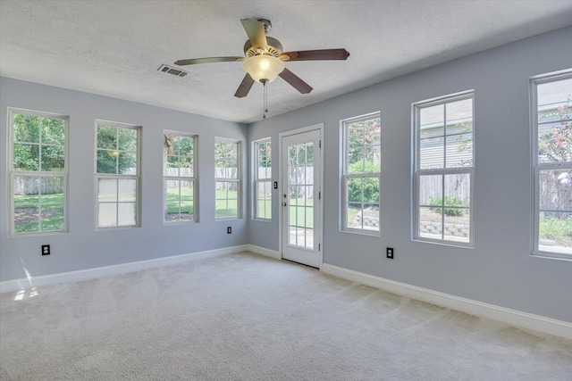 carpeted empty room featuring a textured ceiling and ceiling fan