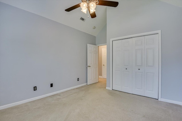 unfurnished bedroom with ceiling fan, a closet, high vaulted ceiling, and light colored carpet