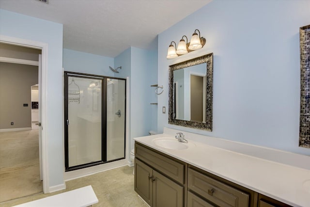 bathroom featuring vanity, toilet, and a shower with door