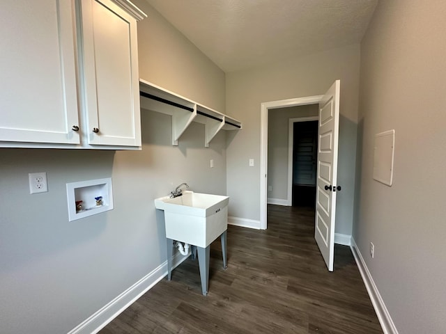 laundry room with cabinets, hookup for a washing machine, and dark hardwood / wood-style flooring