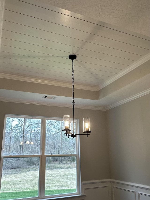 room details with a tray ceiling, an inviting chandelier, and crown molding