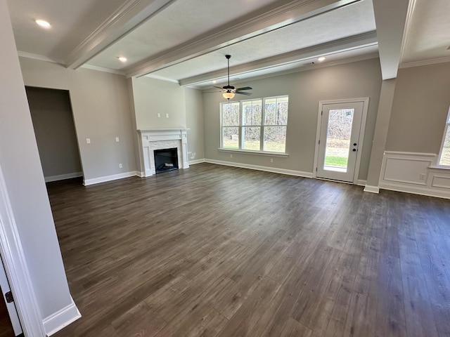 unfurnished living room featuring ornamental molding, ceiling fan, beam ceiling, a fireplace, and dark hardwood / wood-style floors