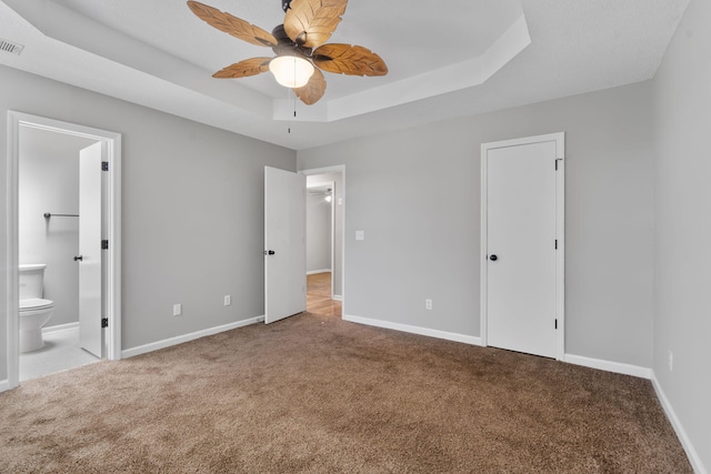 3363 Saddlebrook Dr, Hephzibah, GA 30815 - unfurnished bedroom with carpet floors, a tray ceiling, connected bathroom, and baseboards