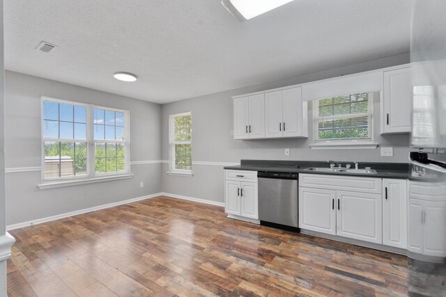 3363 Saddlebrook Dr, Hephzibah, GA 30815 - kitchen featuring stainless steel dishwasher, a sink, dark countertops, white cabinetry, and a textured ceiling