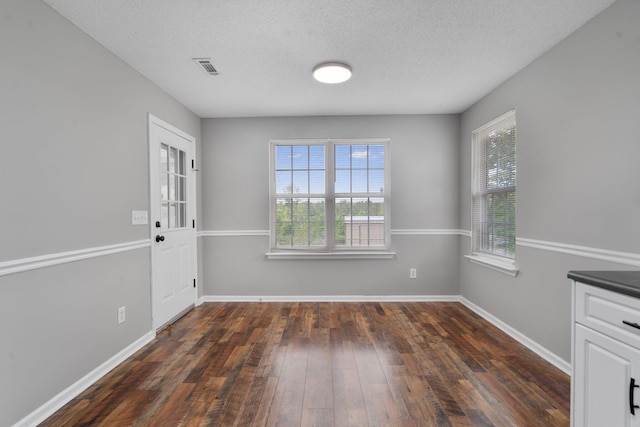 3363 Saddlebrook Dr, Hephzibah, GA 30815 - unfurnished dining area with dark wood-style floors, baseboards, and a textured ceiling