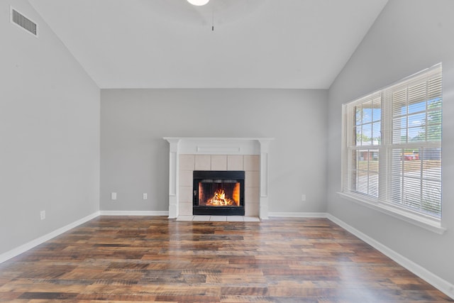 3363 Saddlebrook Dr, Hephzibah, GA 30815 - unfurnished living room with lofted ceiling, wood finished floors, a tiled fireplace, and baseboards