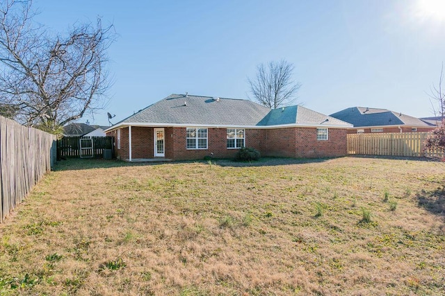 rear view of property with a yard