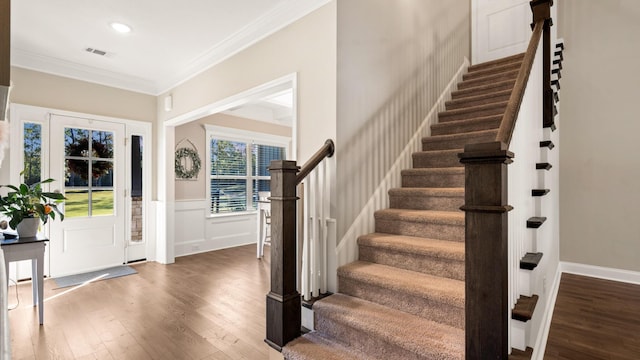 entrance foyer featuring crown molding and dark wood-type flooring