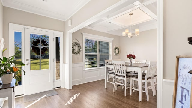 dining room featuring hardwood / wood-style flooring, coffered ceiling, crown molding, and a chandelier