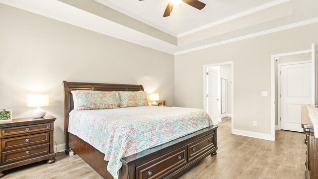 bedroom featuring ceiling fan, a raised ceiling, crown molding, and light hardwood / wood-style flooring