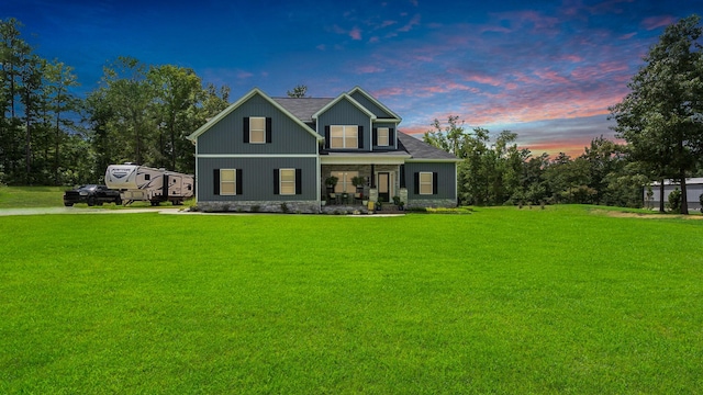 view of front of house with covered porch and a yard