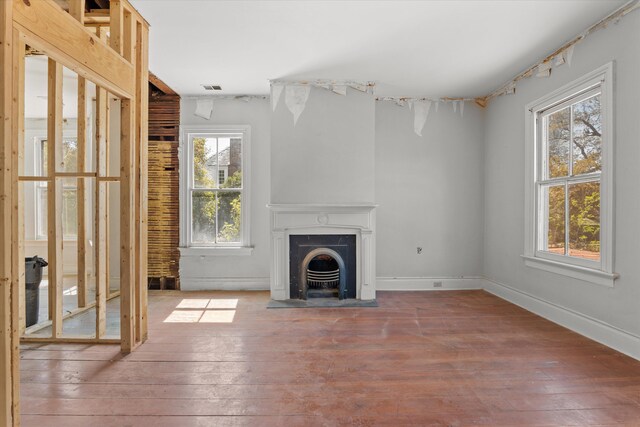 946 Milledge Rd, Augusta, GA 30904 - unfurnished living room featuring healthy amount of natural light, hardwood / wood-style floors, and a fireplace with raised hearth