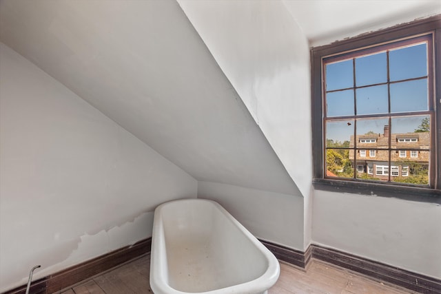 946 Milledge Rd, Augusta, GA 30904 - bathroom featuring hardwood / wood-style floors, a soaking tub, and vaulted ceiling