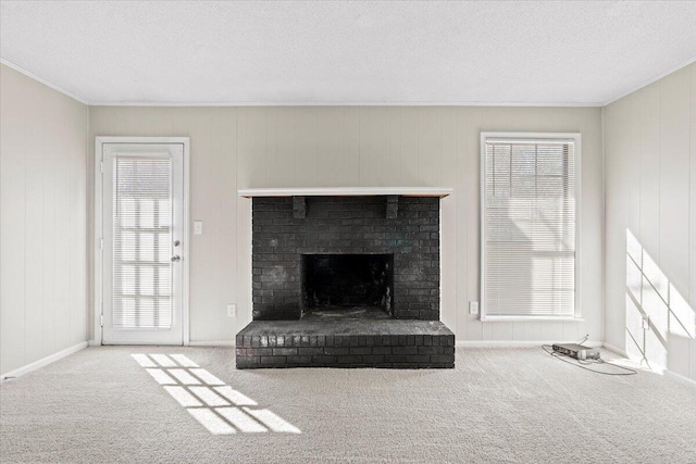 unfurnished living room featuring ornamental molding, carpet floors, a fireplace, and a textured ceiling