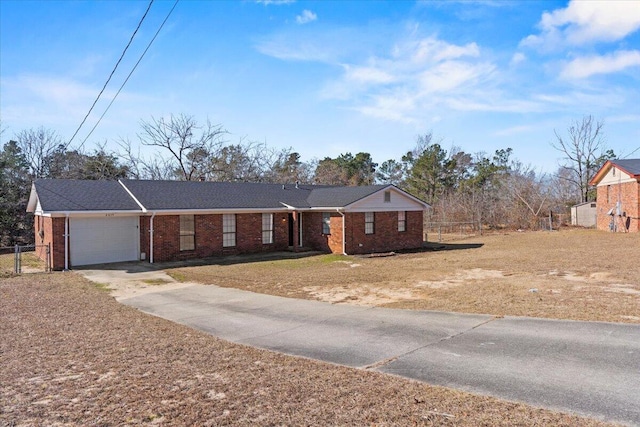 single story home featuring an attached garage, brick siding, fence, driveway, and a front lawn