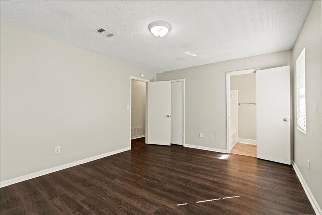 empty room featuring dark wood-type flooring and a textured ceiling