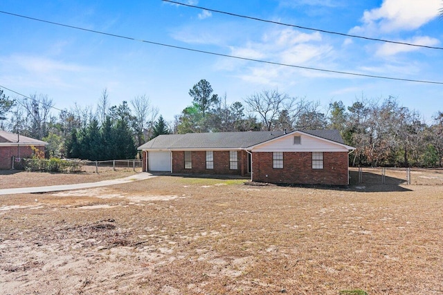 ranch-style house with a garage, driveway, brick siding, and fence