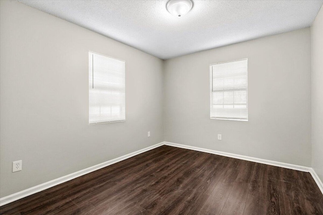 unfurnished room featuring dark hardwood / wood-style flooring and a textured ceiling