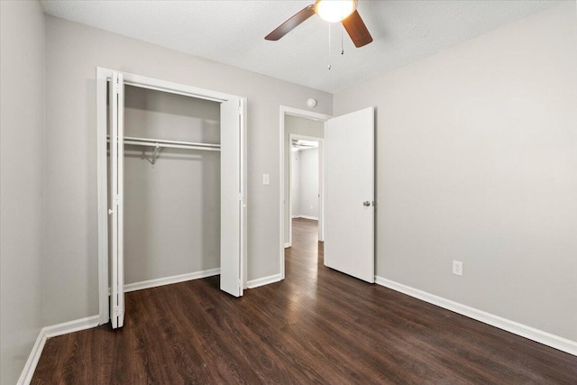 unfurnished bedroom with a closet, dark wood-style flooring, baseboards, and a ceiling fan