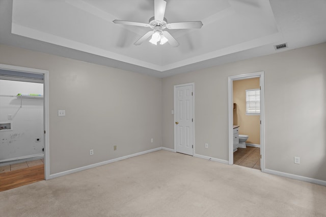 3007 Ashland Way, Grovetown, GA 30813 - unfurnished bedroom featuring a tray ceiling, light carpet, baseboards, and connected bathroom