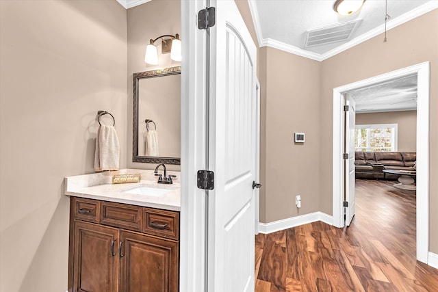 bathroom featuring vanity, wood-type flooring, and ornamental molding