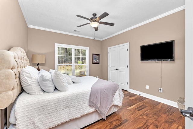 bedroom featuring ornamental molding, dark hardwood / wood-style floors, ceiling fan, and a closet