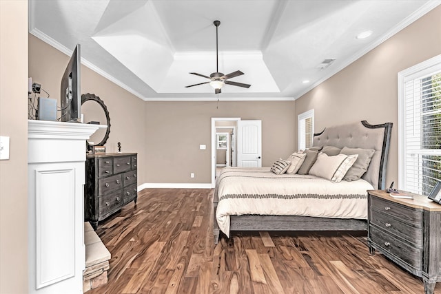 bedroom with a tray ceiling, ornamental molding, dark hardwood / wood-style floors, and ceiling fan