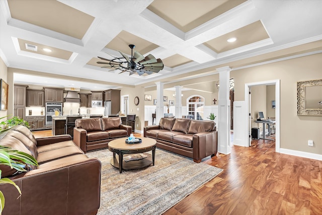 living room with coffered ceiling, decorative columns, crown molding, ceiling fan, and light hardwood / wood-style floors