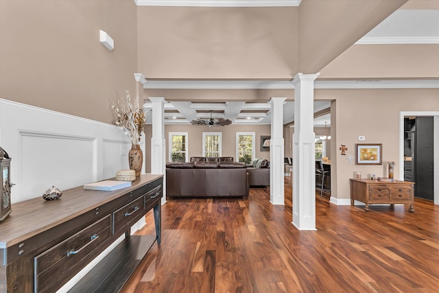 interior space featuring ornamental molding, dark hardwood / wood-style floors, and decorative columns