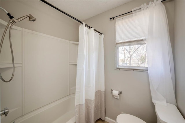 bathroom with shower / bath combination with curtain and toilet