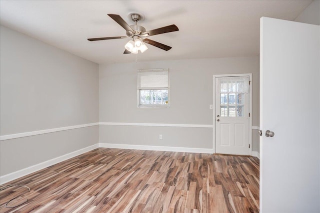 spare room featuring ceiling fan, wood-type flooring, and plenty of natural light