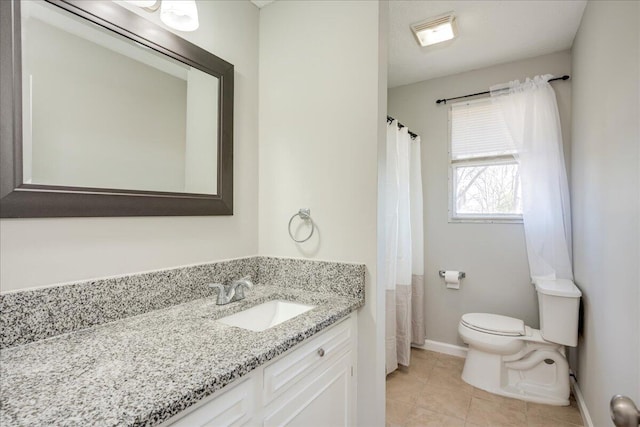 bathroom with toilet, vanity, and tile patterned floors