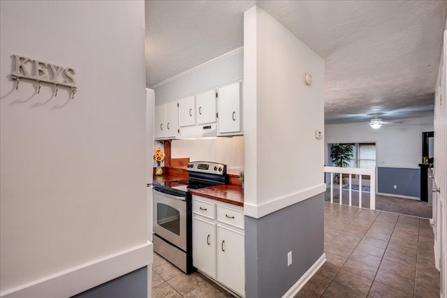 kitchen featuring stainless steel range with electric stovetop, a textured ceiling, exhaust hood, white cabinets, and ceiling fan