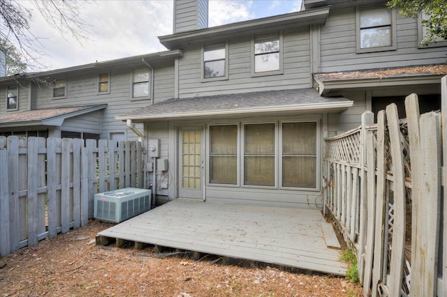 back of house featuring a fenced backyard, cooling unit, a chimney, and a deck