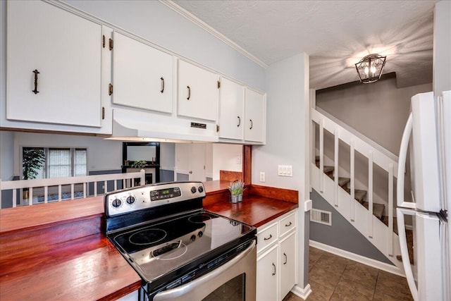 kitchen with electric stove, under cabinet range hood, dark countertops, freestanding refrigerator, and white cabinets