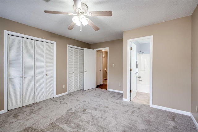 unfurnished bedroom with baseboards, multiple closets, and carpet floors