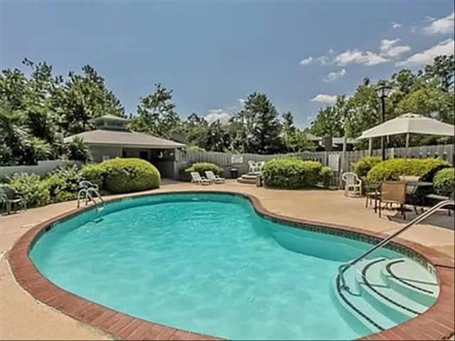 community pool featuring a patio and fence