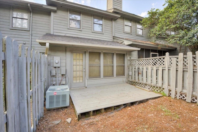 back of house featuring a deck, a chimney, central AC, and fence